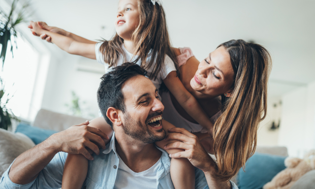 Vater tobt mit zwei Kindern auf dem Boden herum